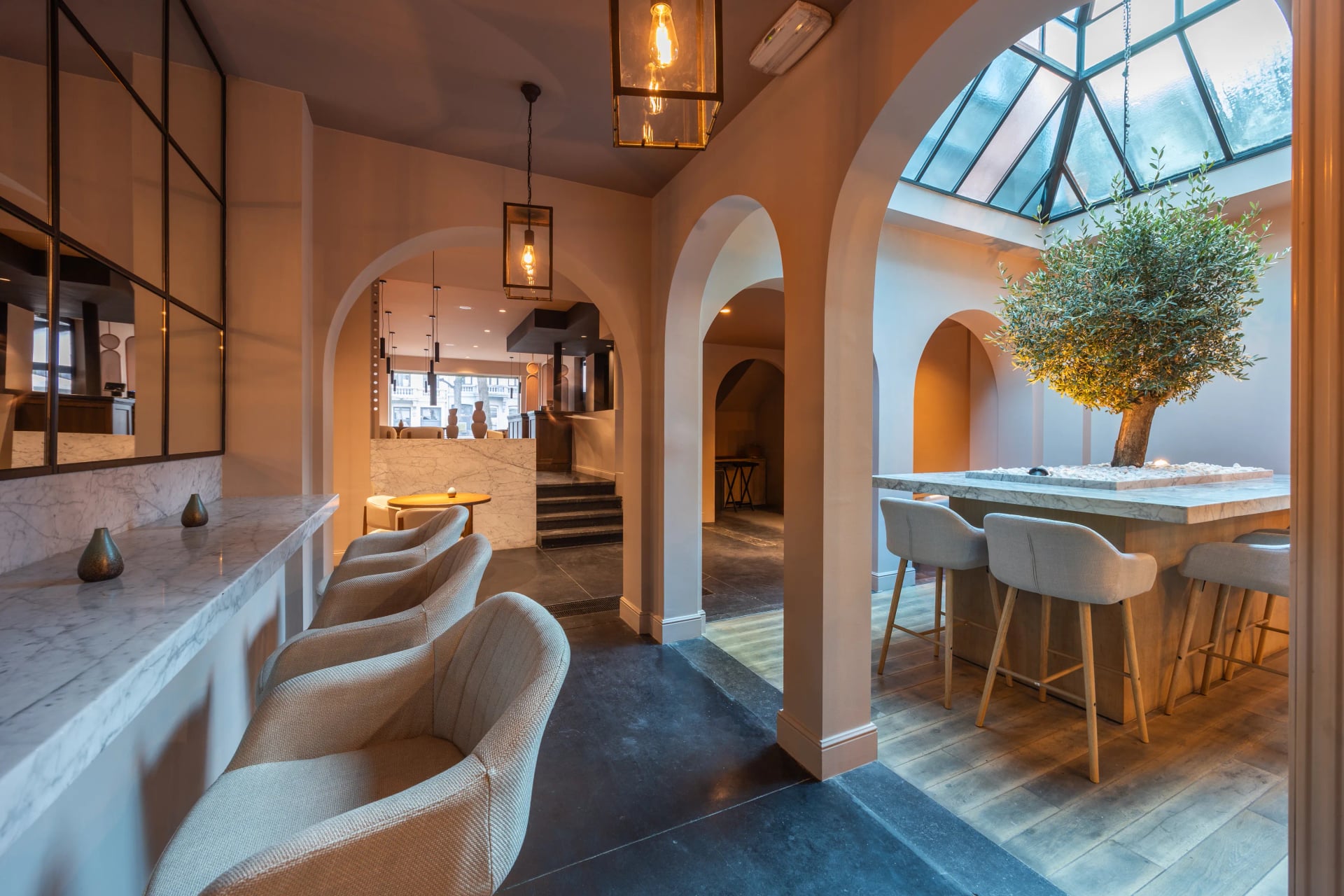 Sfeervol interieur van restaurant MERO in Antwerpen Zuid met marmeren bar en olijfboom